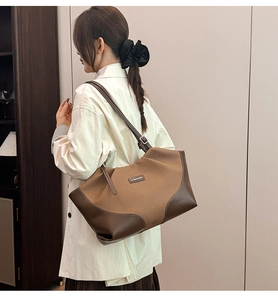 Detail view of large contrast tote bag featuring fashion text and premium leather trim