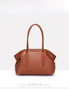 Brown lychee texture leather tote bag with dual slim handles on white background