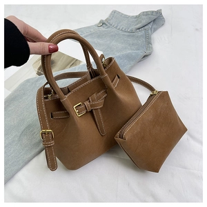 Detailed macro view of the brown leather bucket bag set with contrast stitching details