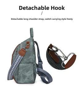 Detail of blue canvas backpack showing adjustable geometric strap and durable metal hooks