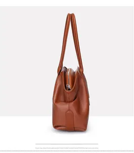 Side view of brown leather tote bag showing spacious structure and silver zipper details