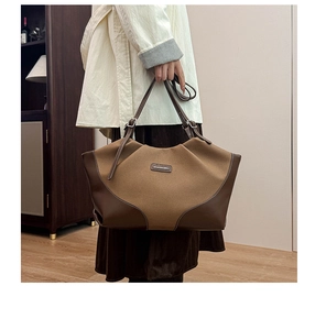 Detail of a large color-block tote bag with leather texture and front fashion tag