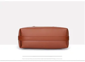 Detail view of the rectangular lychee grain leather bottom on a brown tote handbag