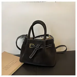 Detail of black leather bucket bag with contrast stitching and vintage gold buckle