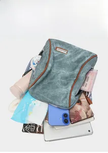 Detail showing spacious interior of a green soft leather backpack with daily essentials