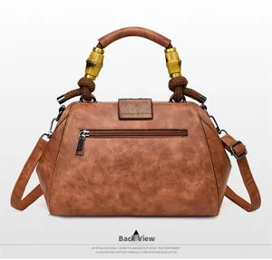 Rear view of brown vintage PU leather handbag featuring bamboo-style metal hardware