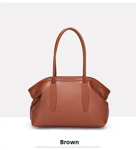 Close-up of brown pebbled leather texture and fine stitching on a tote handbag