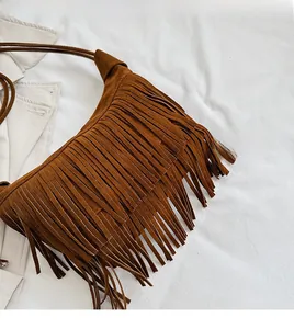 Detailed view of the soft brown suede texture and long fringe tassels on the shoulder bag