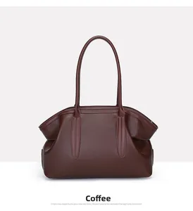 Detail of coffee brown leather tote bag showing fine lychee grain texture and stitching