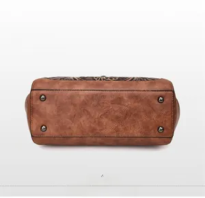 Detail of vintage brown handbag bottom featuring four metal feet and pebble leather texture