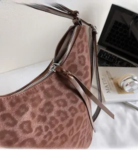 Detail of silver zipper and satin leopard print fabric on a versatile shoulder bag