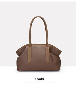 Detail of khaki leather tote bag showing lychee grain texture and pleated top edge