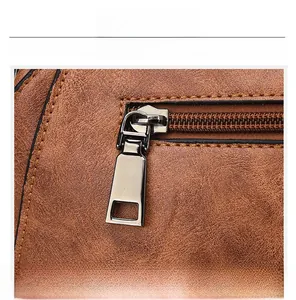 Close-up of matte dark grey zipper and brown litchi grain leather on a vintage handbag