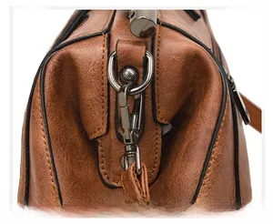 Detail of vintage tote featuring detachable metal swivel hook and caramel leather texture