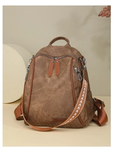 Detail view of brown vintage backpack with textured fabric and geometric woven strap