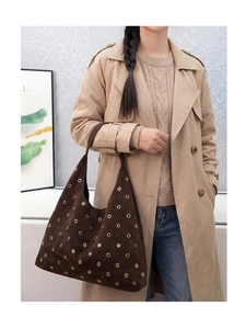 Close-up of vintage brown suede shoulder bag with gold metal eyelet rivet details
