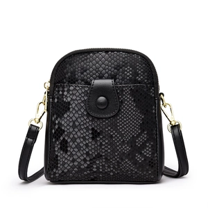 Minimalist black snakeskin embossed crossbody bag with gold hardware and flap pocket