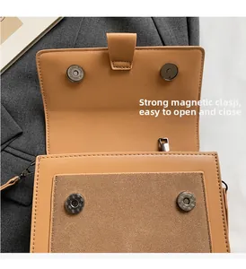 Detail of dual magnetic snap closures on camel PU leather and suede patchwork crossbody bag