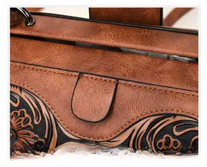 Detailed view of vintage floral embossed leather with precision stitching on a tote bag