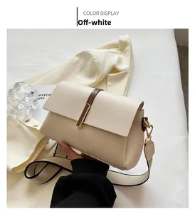 Detail of off-white crossbody bag with lychee texture and gold metal buckle closure