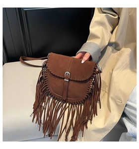 Détail du sac besace bohème avec de longues franges et des coutures tressées en daim