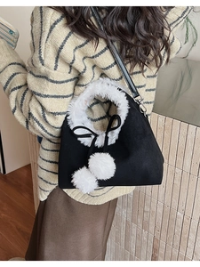 Detail of vintage bucket bag with white plush fur trim and soft hanging pom-poms
