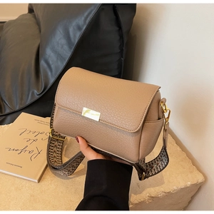 Close-up of khaki leather crossbody bag with lychee texture and gold buckle