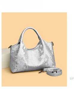 Close-up of silver textured shoulder bag with scale pattern and detachable metal strap