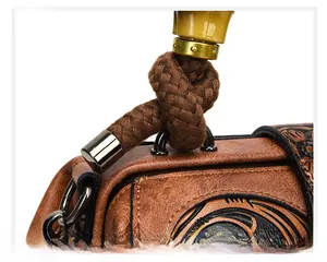 Close-up of brown textured leather bag with embossed floral patterns and woven handles