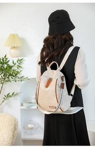 Close-up of beige fashion backpack featuring a stylish geometric woven shoulder strap detail