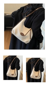 Detail of a cream canvas hobo bag with brown leather trim and oval decorative patch
