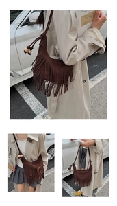 Detailed view of brown suede half-moon shoulder bag with long fringes and wooden beads