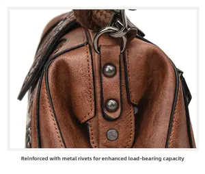 Detail of metal rivets and pleat design on vintage brown PU leather handbag