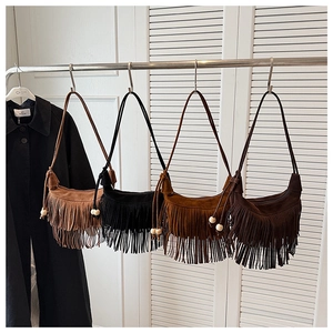 Detail view of khaki black and brown suede crescent bags with long fringe tassels