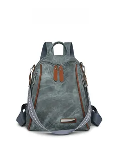 Front detail of gray-blue backpack with brown trim and stylish patterned strap accents