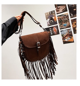 Détail du sac besace en daim marron foncé à franges avec coutures tressées de style bohème