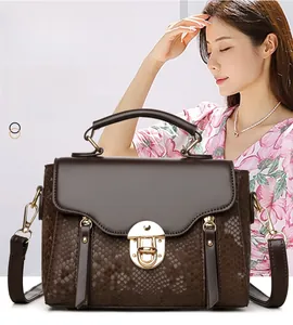 Detail of retro brown snakeskin embossed handbag with elegant gold metal clasp