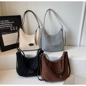 Detailed view of four crescent moon leopard print shoulder bags in assorted colors