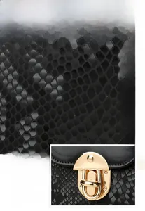 Detail of black snake-patterned leather texture and golden metal twist lock on a handbag