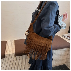 Detail of brown suede tassel crossbody bag with wooden beads and bohemian fringe style