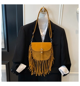 Détail du sac besace en daim jaune avec de longues franges et boucle argentée