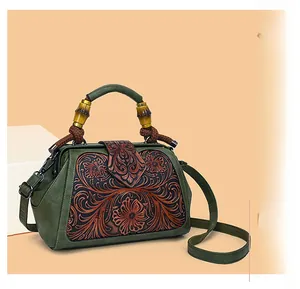 Detail of green floral embossed bag with bamboo handle and vintage metal clasp