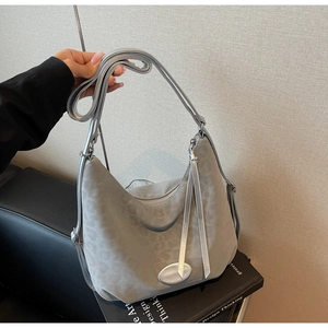 Detail of grey leopard print crescent bag with silver strap and elegant fringe pendant