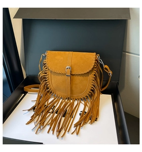 Détail du sac besace bohème jaune avec de longues franges et bandoulière sur coffret