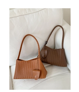Detailed view of woven texture and decorative buckle on brown leather shoulder bags