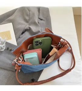 Internal view of denim crossbody bucket bag showing spacious storage for makeup and wallet