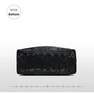 Detail view of the black snakeskin texture bottom with precise stitching on shoulder bag