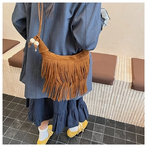 Detail of brown suede hobo bag with long fringes and white beads on the shoulder strap