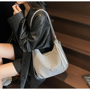Detail of silver leopard print tote bag with metallic logo plate and stylish tassel zip