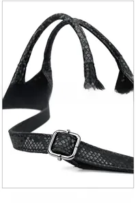 Detail of snake skin texture handbag featuring dual handles and adjustable metal buckle strap